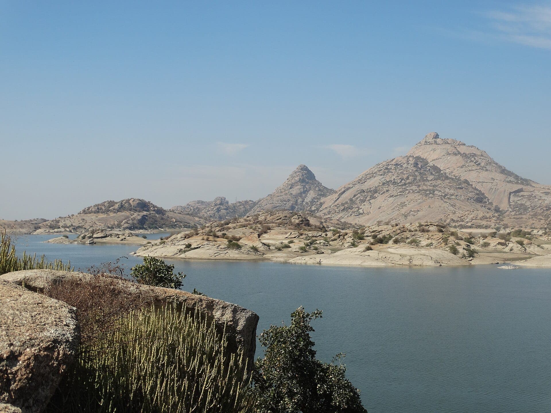 Bare granite hills rising beyond the water of the Jawai dam in Rajasthan