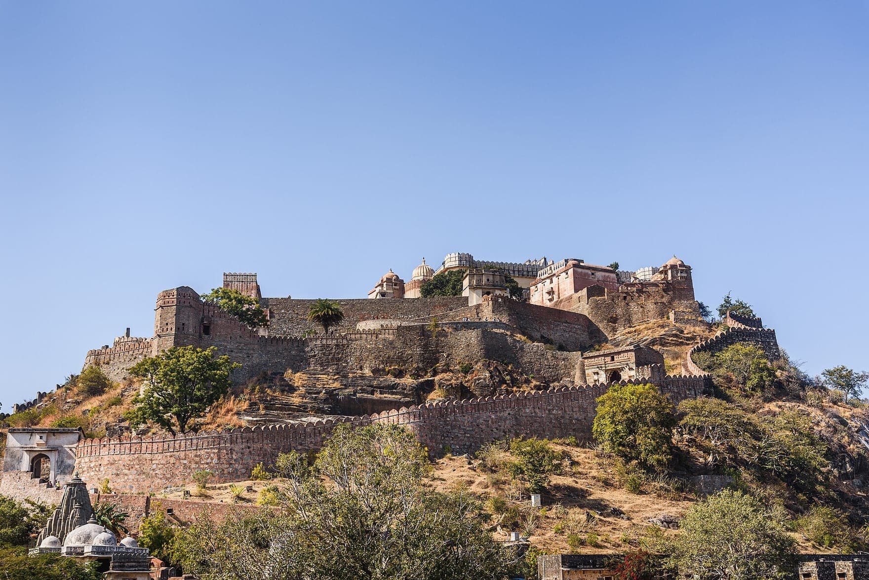 The palace buildings of Kumbhalgarh Fort rising above stone walls on a rocky hilltop