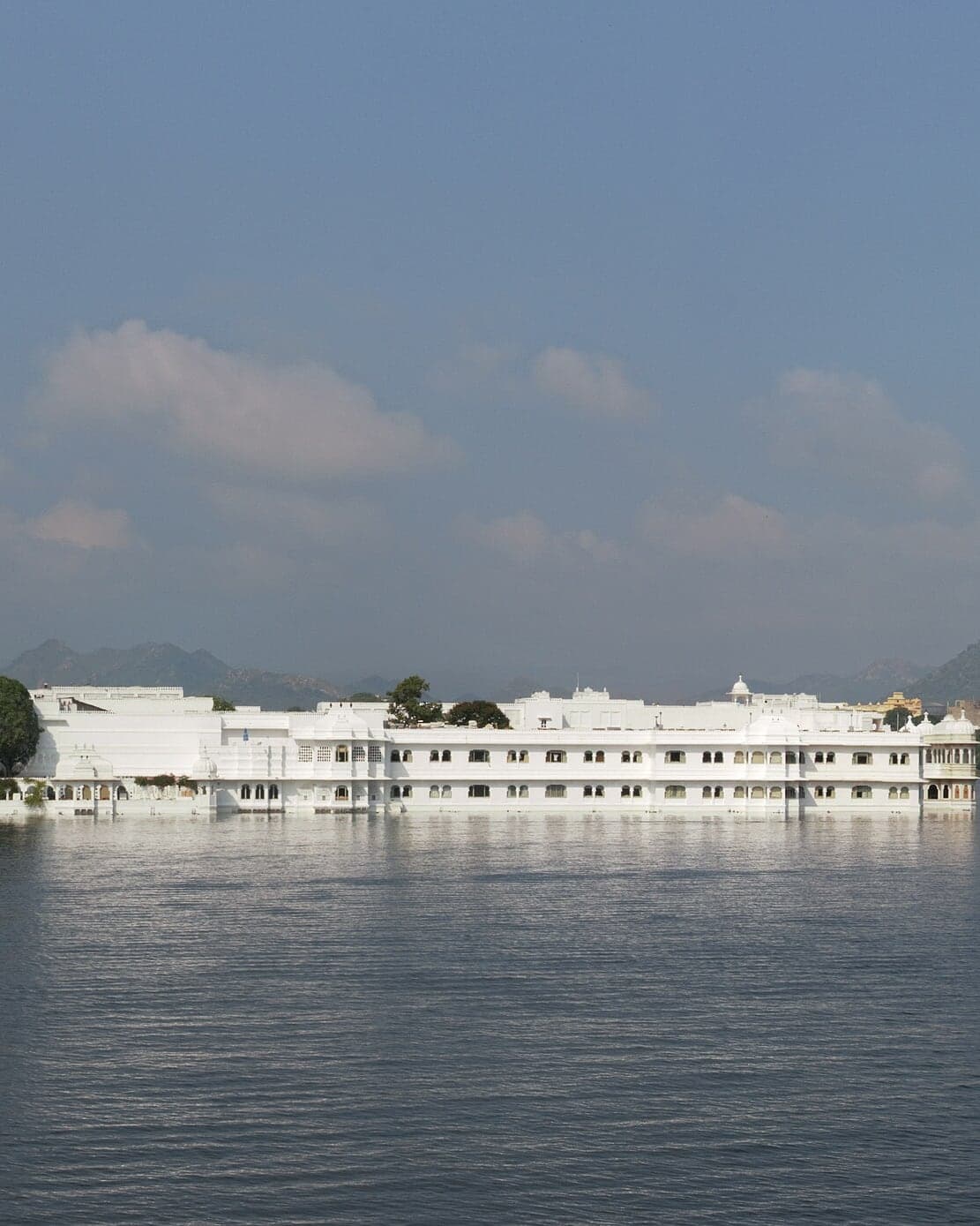 The white Lake Palace on Lake Pichola with the hills behind