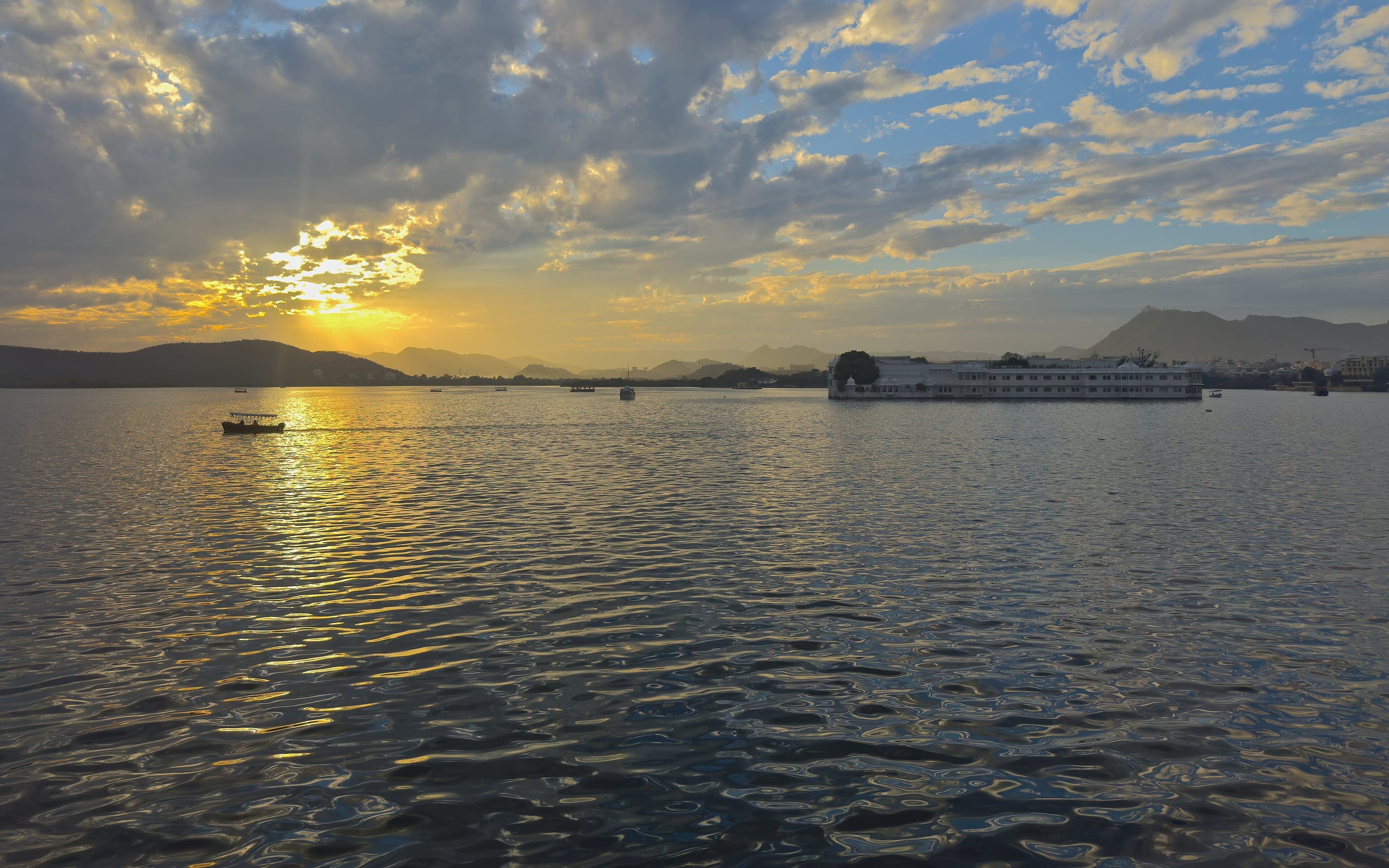 The sun setting over Lake Pichola, Udaipur, with the hills beyond