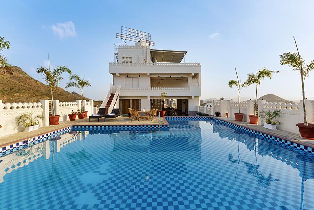 The blue-tiled rooftop pool beside the hotel’s upper terrace