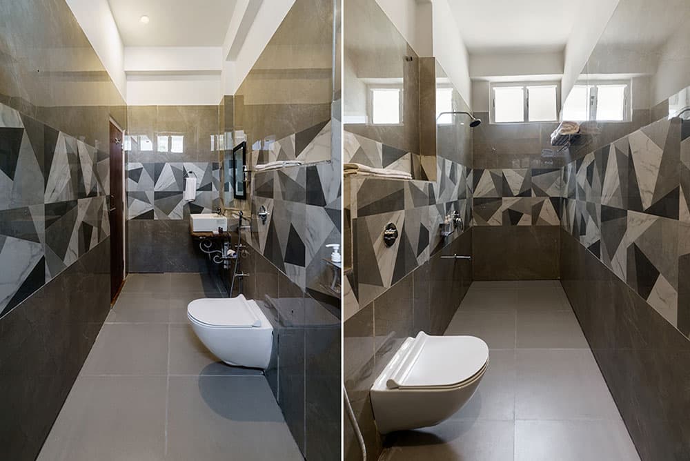 Super Deluxe Room bathroom with grey geometric tiles and a glass-screened shower