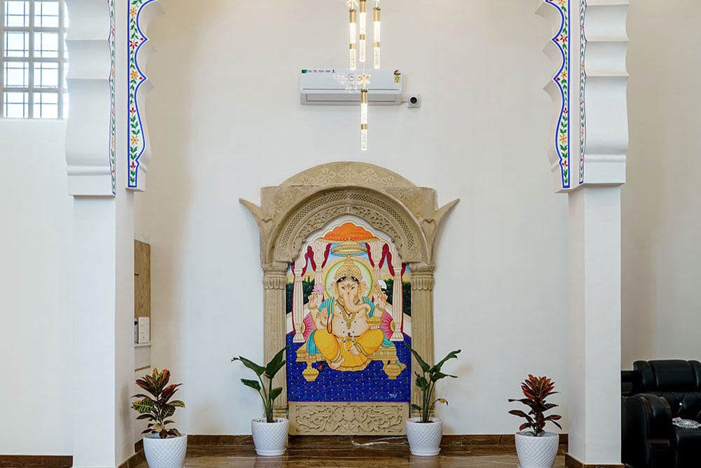 Lobby wall with a carved stone niche holding a colourful Ganesha mural