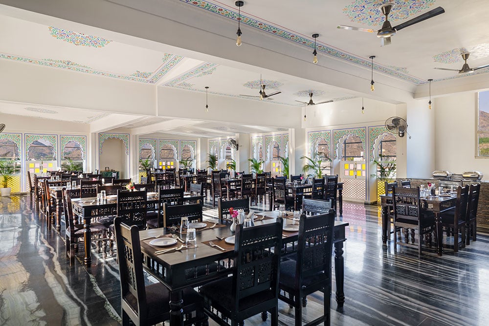 The restaurant’s long dining hall with dark carved chairs and arched windows